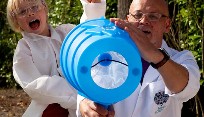 Mad Science docent en deelnemer doen een proefje buiten