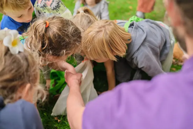 kinderen leren buiten in de tuin in een groep over duurzaam onderwijs