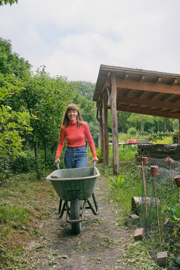 persoon met kruiwagen in de moestuin van stadsboerderij eilandsteede stadstuin