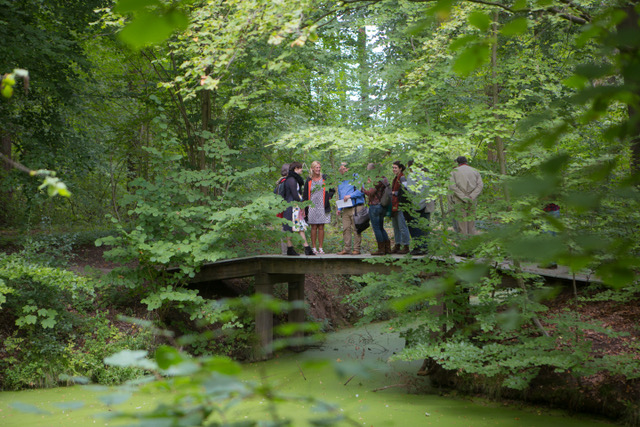 Een groep bezoekers op een brug tijdens een excursie door Amelisweerd.