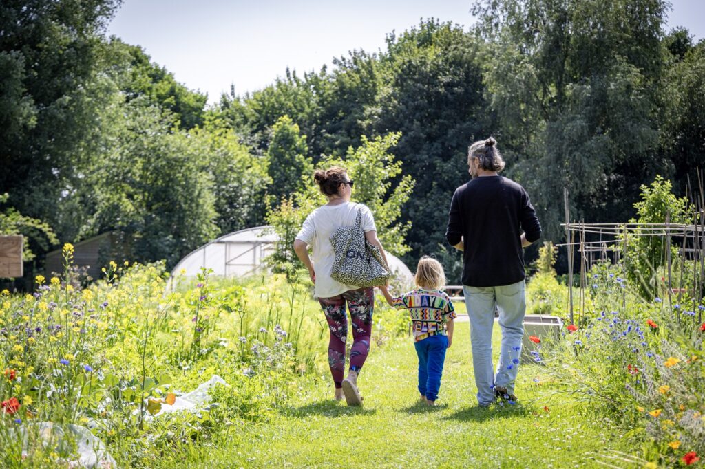 Ouders met kind op de tuin bij stadstuin plutodreef