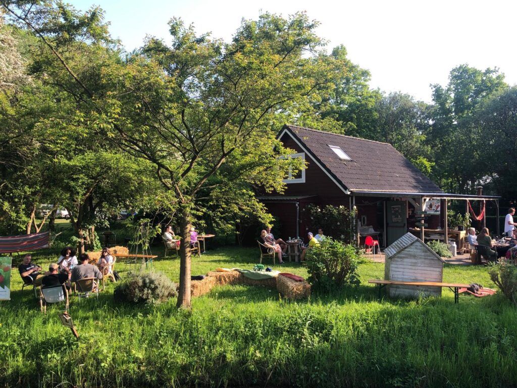 mensen op terras tussen het groen stadstuin tuincafe zuilen