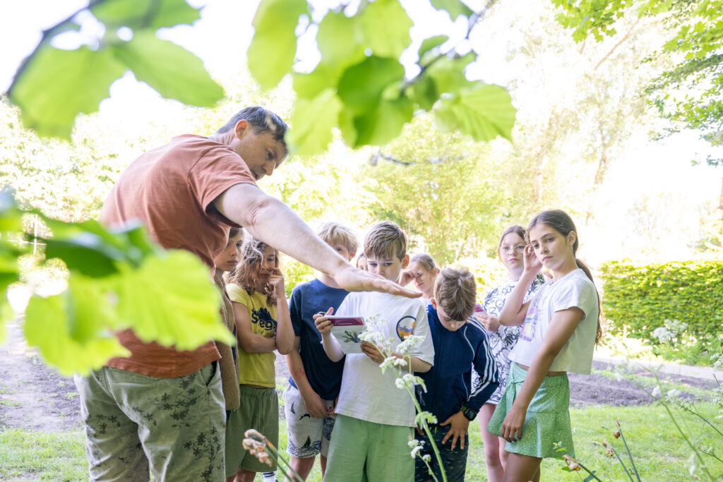 persoon vertelt kinderen over de natuur in het groen